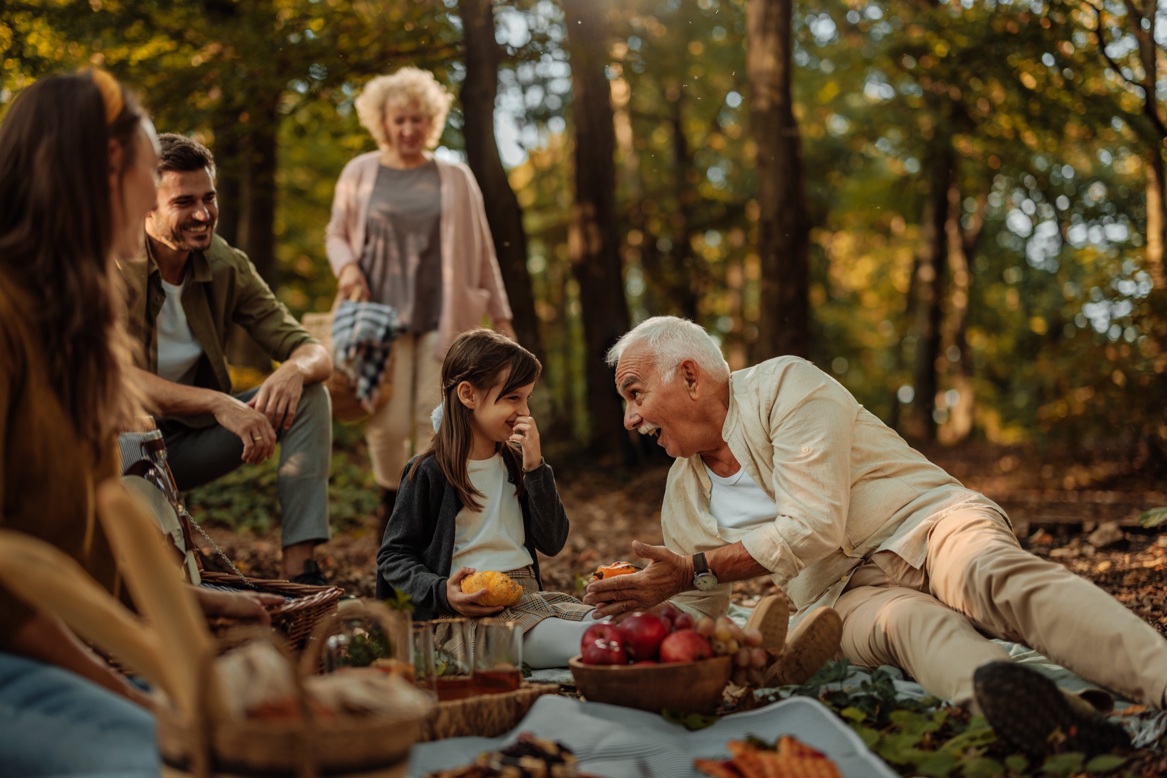 Multi-generational family enjoying a picnic together outdoors